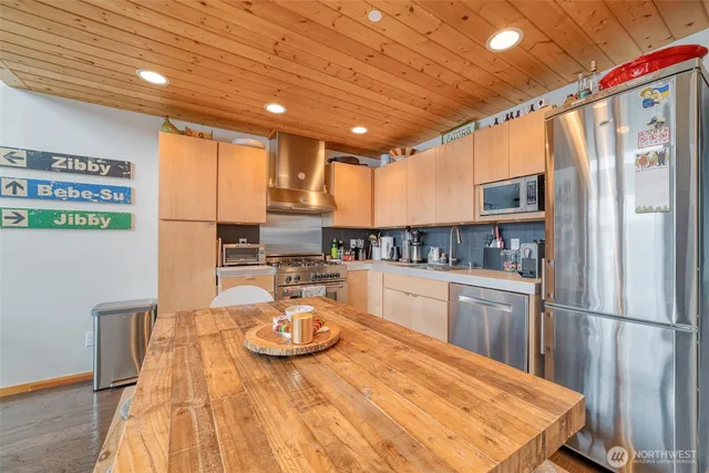 a kitchen with stainless steel appliances granite countertop a sink refrigerator and cabinets