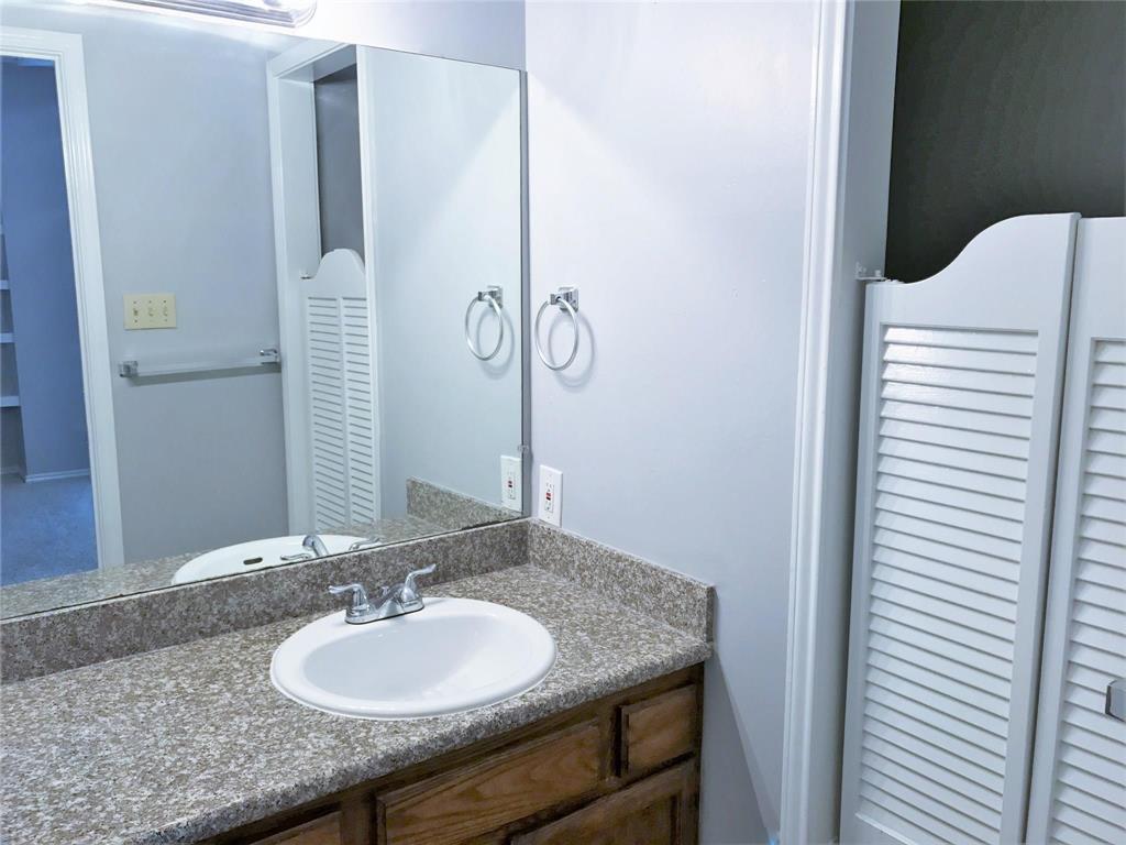 9601 Forest Lane, Unit 1313 Dallas, TX 75243 - Photo 9 of 19 a bathroom with a granite countertop sink and a mirror