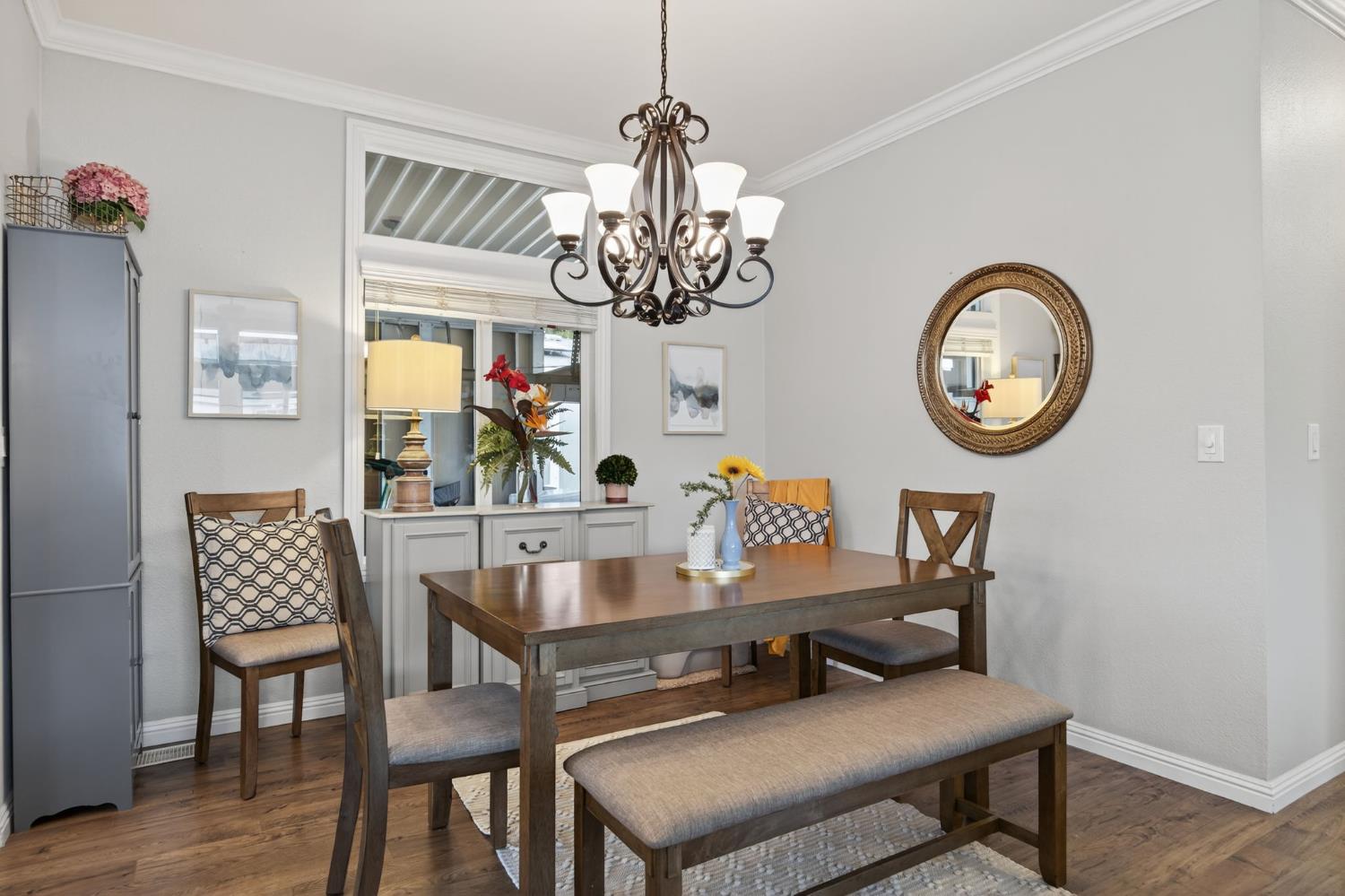 1885 Maricopa Highway, Unit 1 Ojai, CA 93023 - Photo 13 of 36 a dining room with wooden floor a chandelier a wooden table and chairs