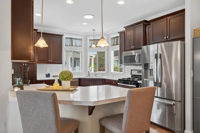 a large kitchen with stainless steel appliances granite countertop a stove and a sink