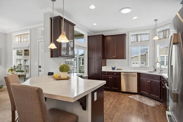a kitchen with stainless steel appliances granite countertop a sink and a refrigerator
