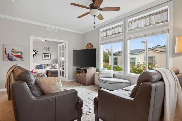 a living room with furniture a flat screen tv and large window