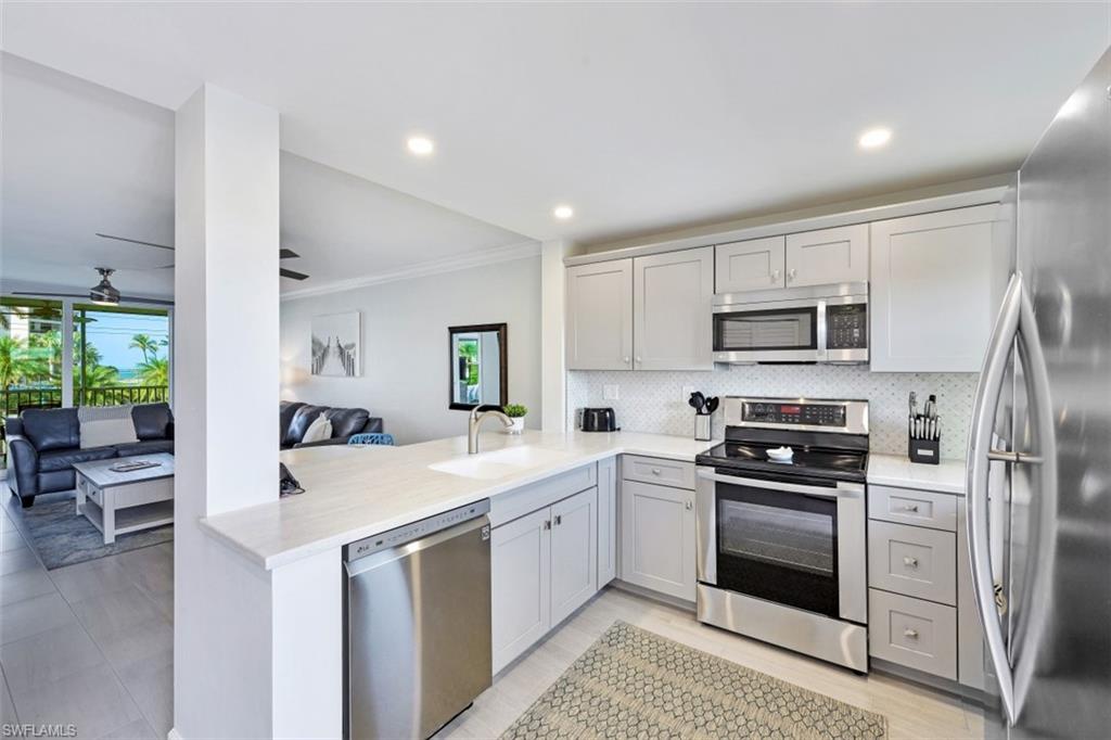 a kitchen with a sink white cabinets and stainless steel appliances
