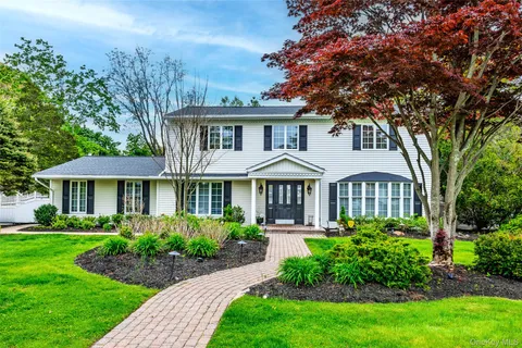 a front view of a house with a garden and plants
