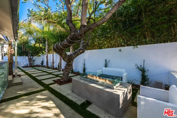 a view of a backyard with couches and a fire pit