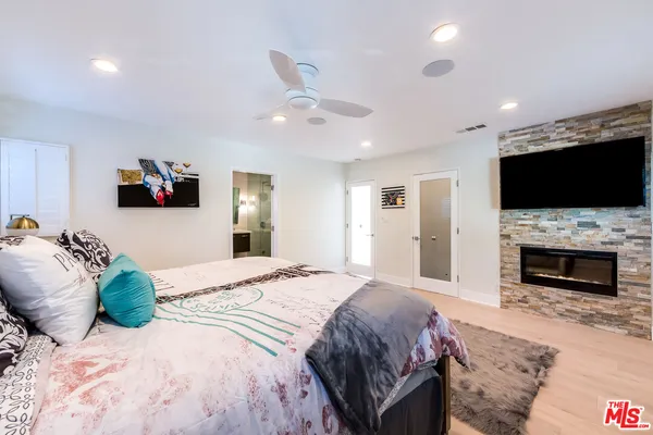 a spacious bedroom with a bed and a flat screen tv