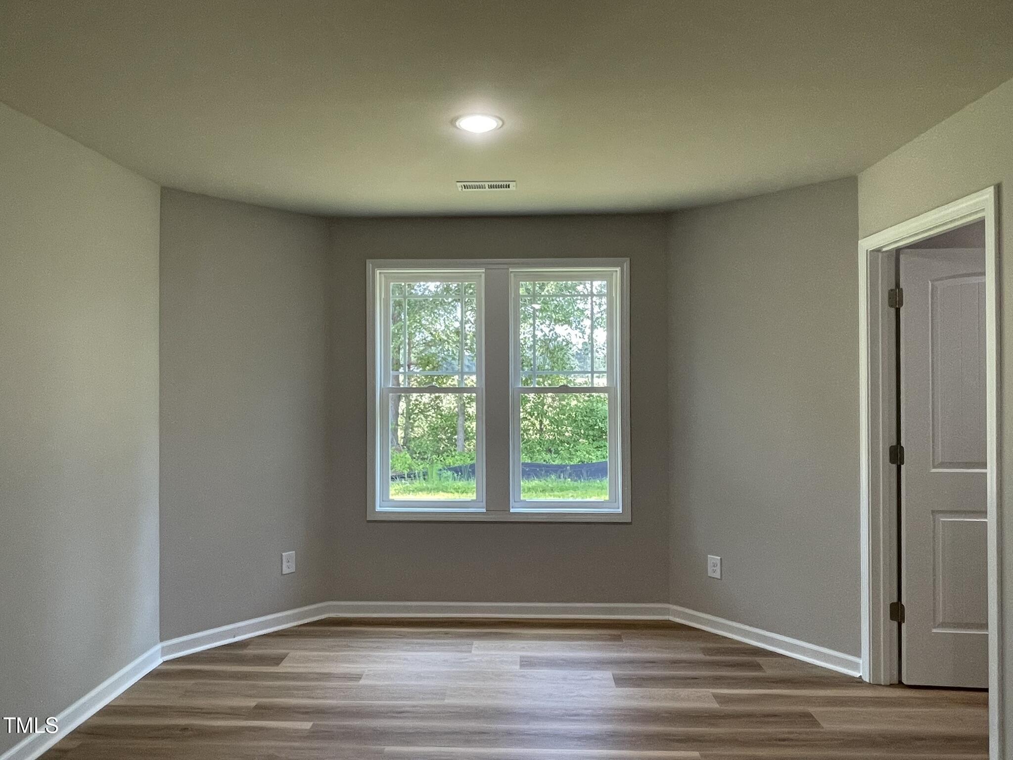 168 Oakfield Trce Drive Four Oaks, NC 27524 - Photo 8 of 19 an empty room with wooden floor and windows