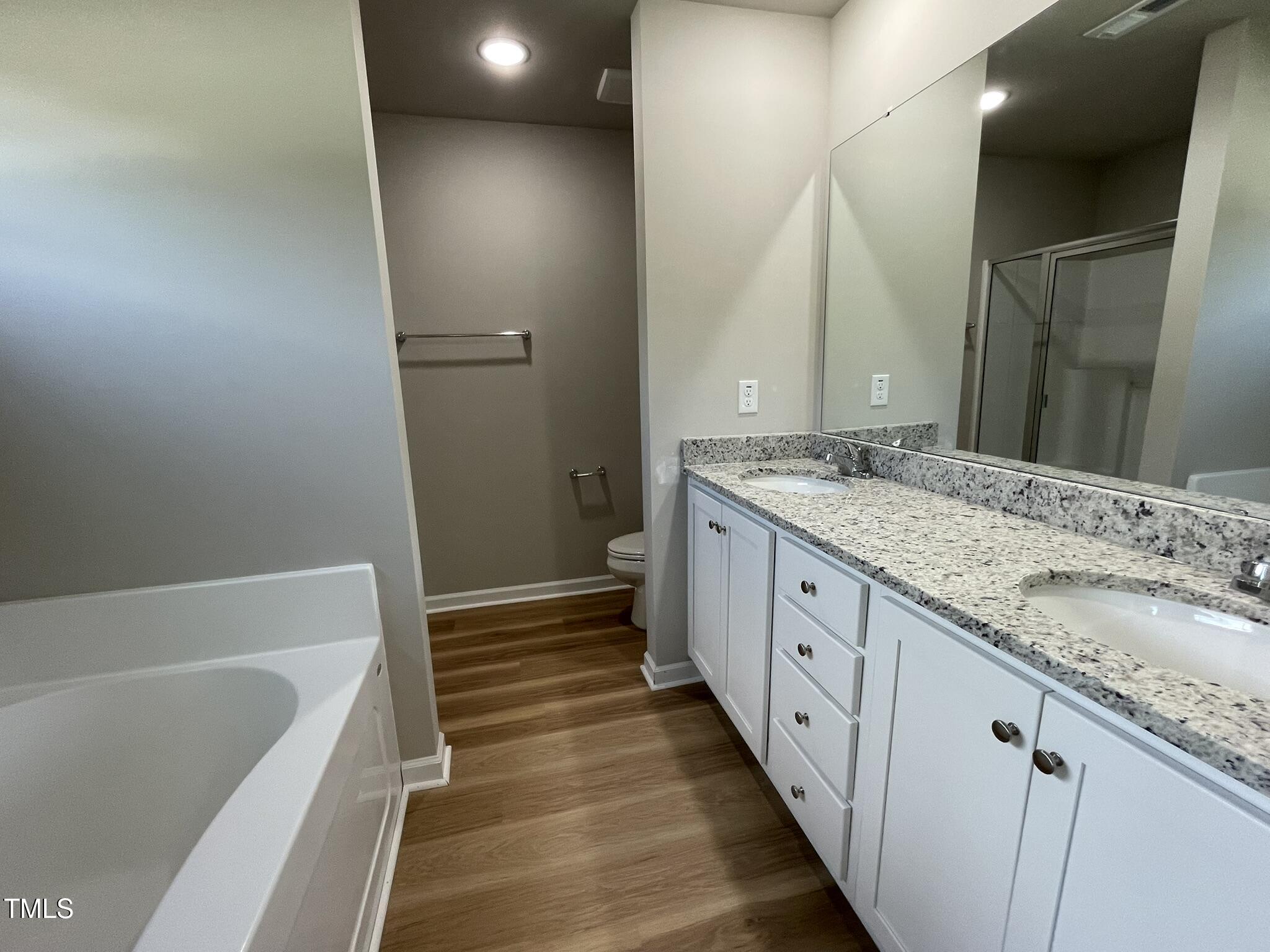 168 Oakfield Trce Drive Four Oaks, NC 27524 - Photo 10 of 19 a spacious bathroom with a granite countertop sink and a mirror