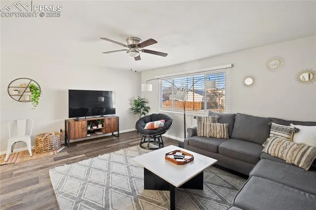 a living room with furniture a flat screen tv and a large window