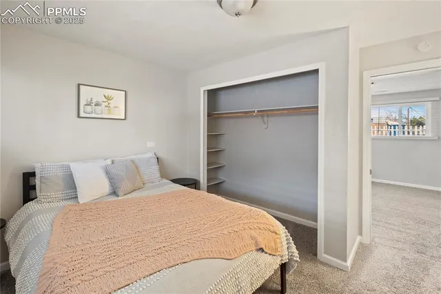 a bedroom with a bed and painting on the wall