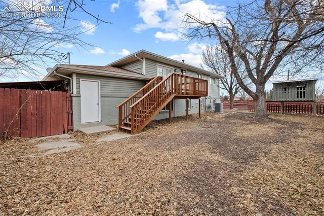 a view of a house with a yard and wooden fence
