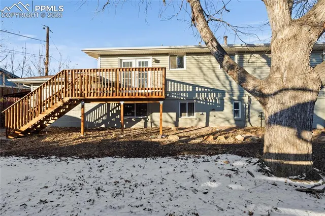 a view of a brick house with a small yard and wooden fence