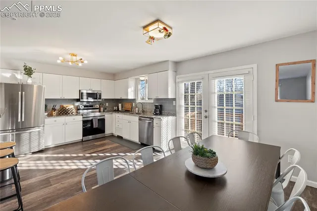a kitchen with a refrigerator and white cabinets