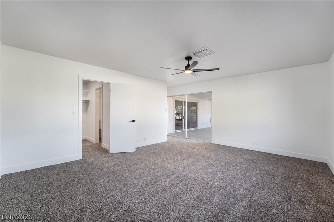 429 Crestway Road Henderson, NV 89015 - Photo 25 of 56 A spacious bedroom featuring soft carpeting and direct access to an outdoor area.