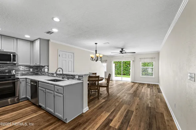 a kitchen with a refrigerator a microwave a sink and cabinets