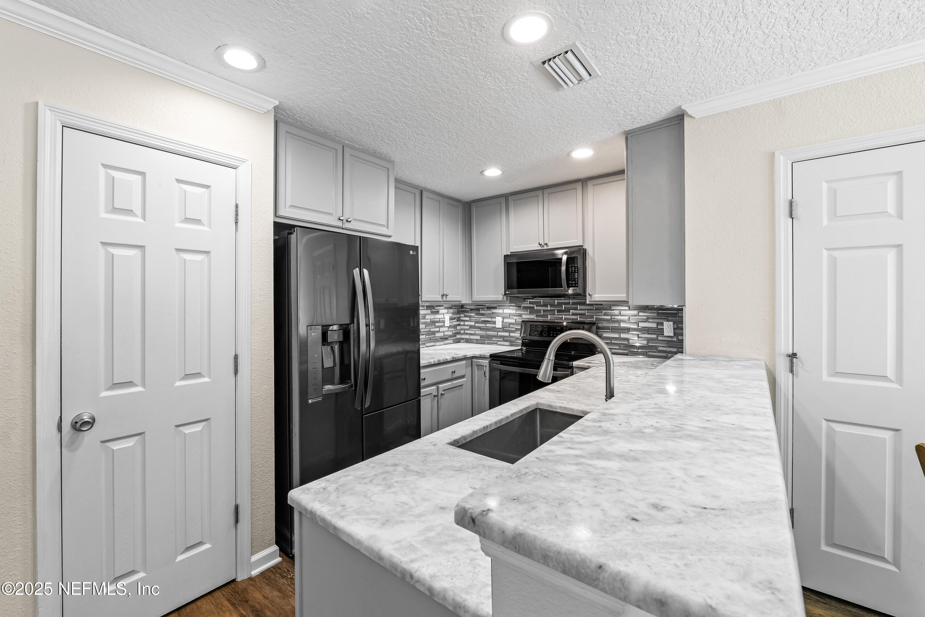 295 Islander Circle St. Augustine, FL 32080 - Photo 15 of 34 a kitchen with a refrigerator a microwave a sink and cabinets