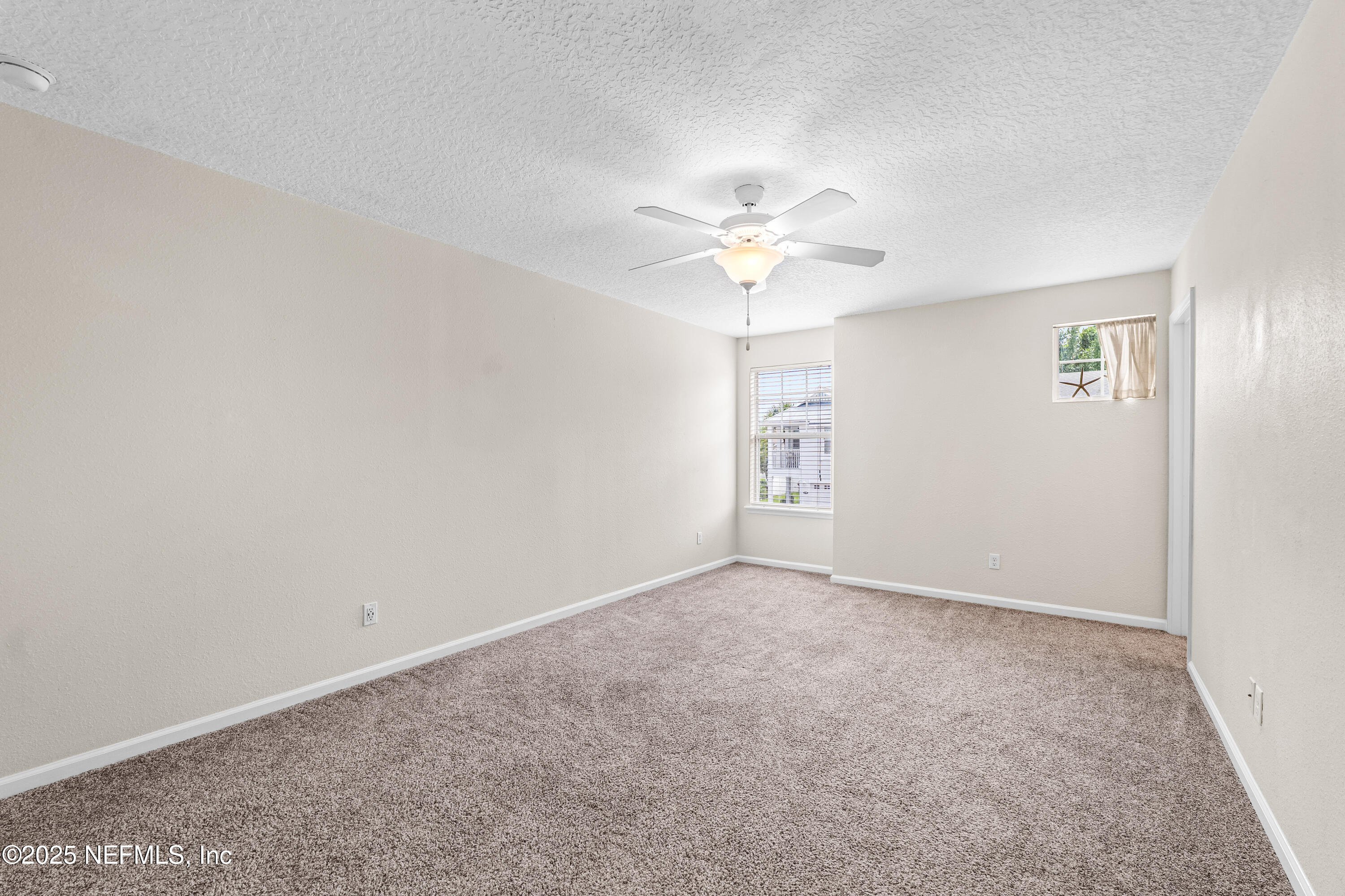 295 Islander Circle St. Augustine, FL 32080 - Photo 23 of 34 an empty room with windows and fan