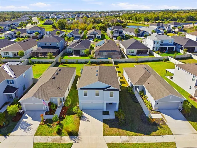 an aerial view of residential houses with outdoor space and swimming pool