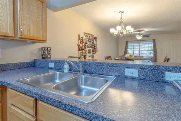 a kitchen with granite countertop a sink a counter top space and cabinets