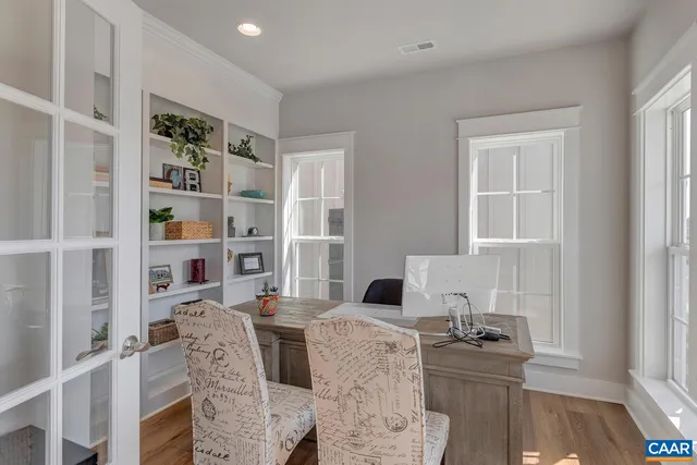 a living room with furniture a rug and a book shelf