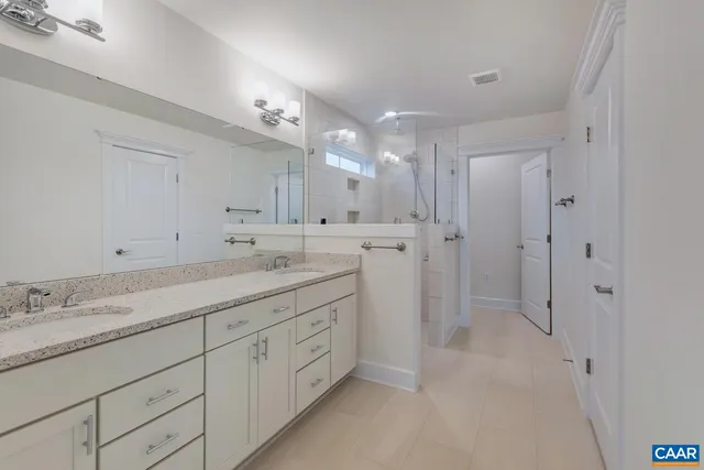 a spacious bathroom with a granite countertop sink mirror and a shower
