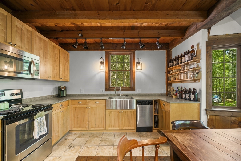 180 Holtshire Road Orange, MA 01364 - Photo 12 of 22 a kitchen with stainless steel appliances granite countertop a stove a sink and a microwave