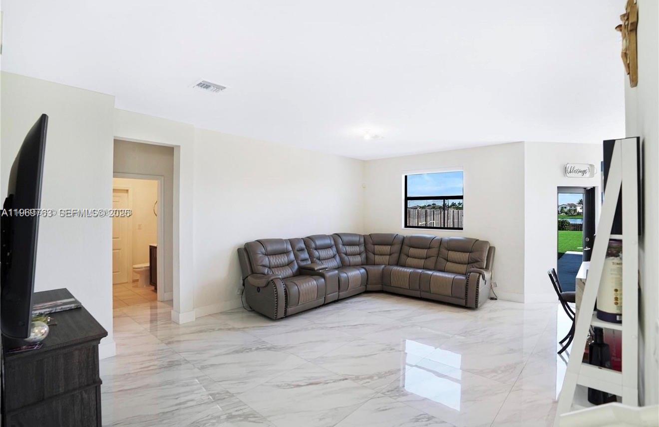 10321 Southwest 232nd Street Cutler Bay, FL 33190 - Photo 13 of 49 a living room with furniture and a flat screen tv