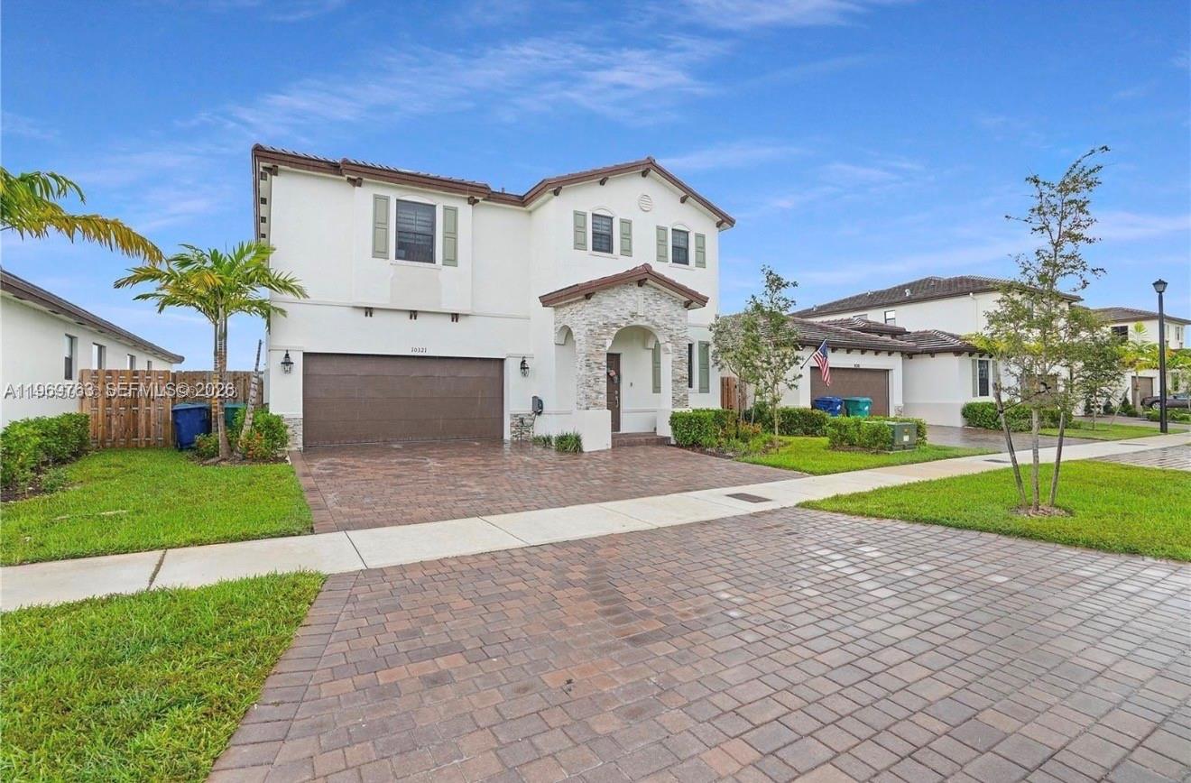 10321 Southwest 232nd Street Cutler Bay, FL 33190 - Photo 2 of 49 a front view of a house with a yard and garage