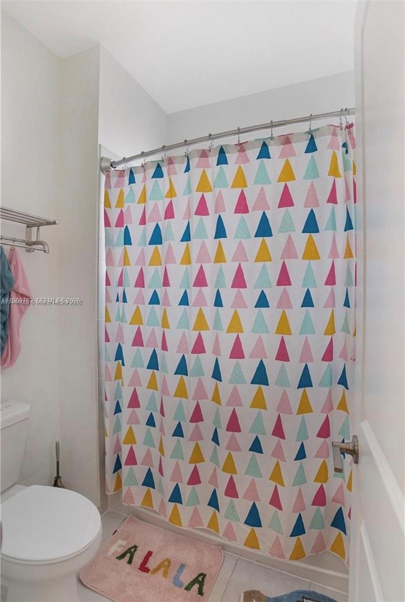10321 Southwest 232nd Street Cutler Bay, FL 33190 - Photo 24 of 49 a bathroom with a toilet and a shower curtain