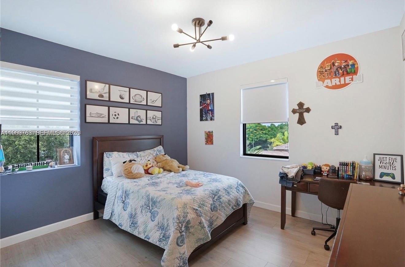 10321 Southwest 232nd Street Cutler Bay, FL 33190 - Photo 25 of 49 a bedroom with a bed and a table in it with window