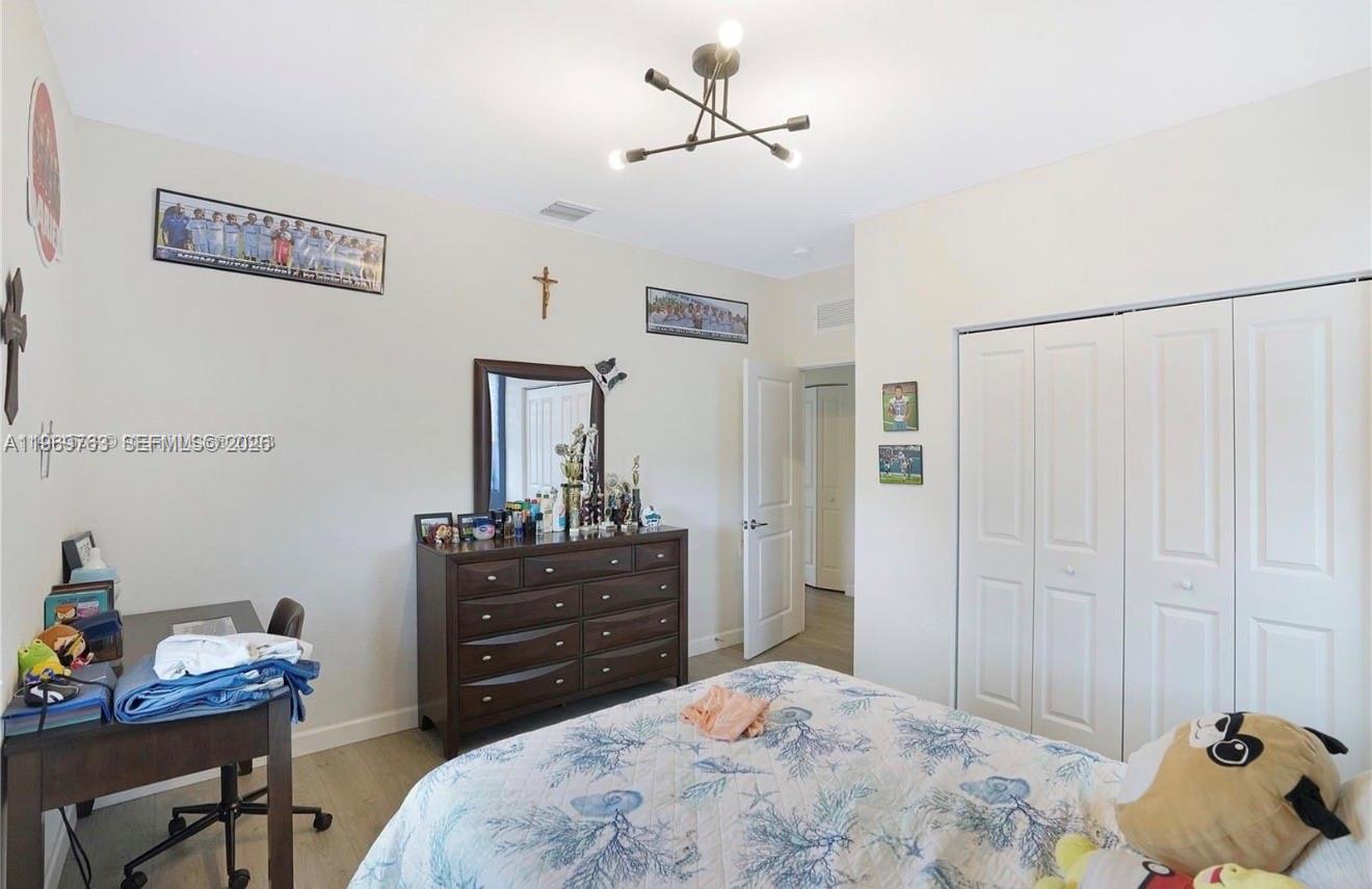 10321 Southwest 232nd Street Cutler Bay, FL 33190 - Photo 27 of 49 a bedroom with a bed and a dresser in it