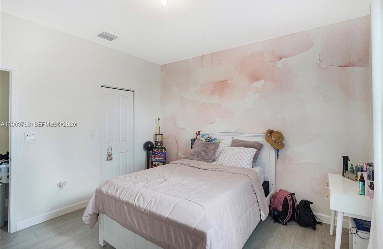 10321 Southwest 232nd Street Cutler Bay, FL 33190 - Photo 35 of 49 a bedroom with a bed and a table