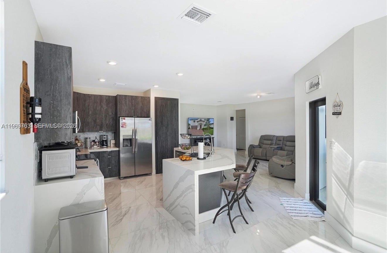 10321 Southwest 232nd Street Cutler Bay, FL 33190 - Photo 7 of 49 a kitchen with stainless steel appliances kitchen island granite countertop a refrigerator and a stove