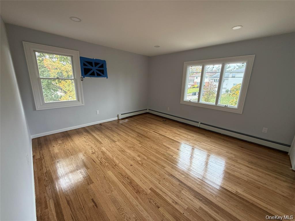 324 Buckingham Road Cedarhurst, NY 11516 - Photo 8 of 12 a view of an empty room with wooden floor and a window