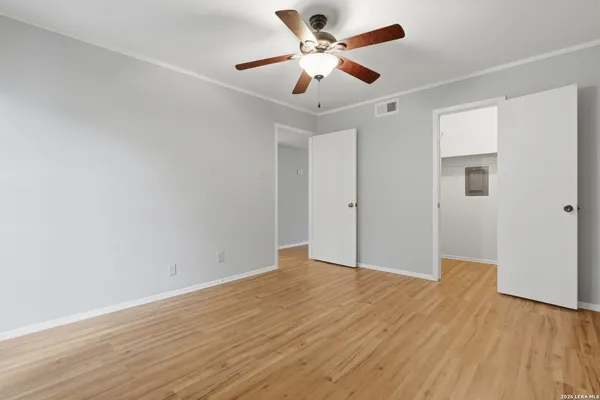 a view of an empty room with window and wooden floor
