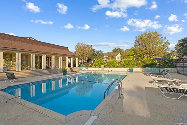 a view of a swimming pool with a lounge chair and floor to ceiling window