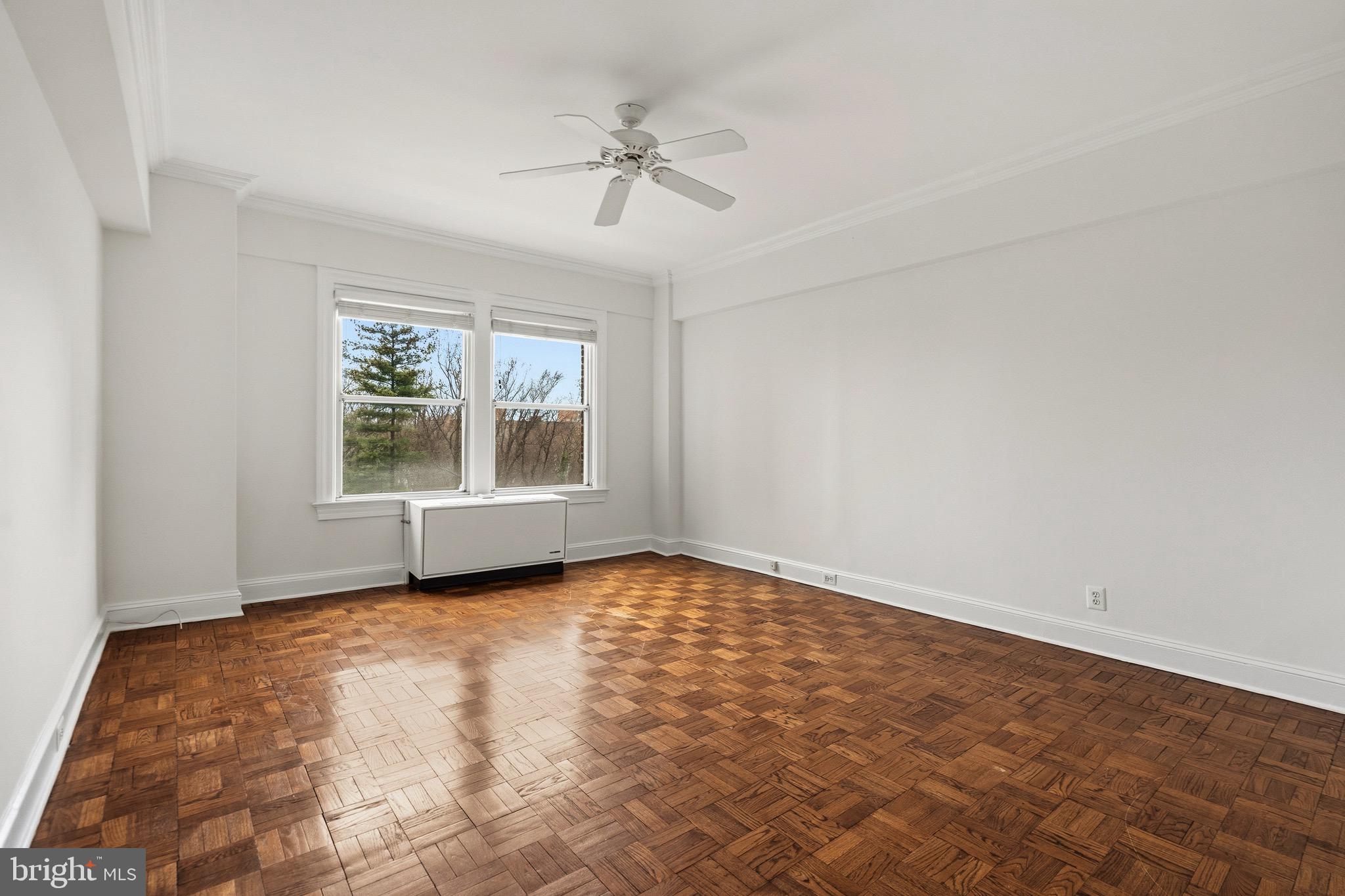 4000 Cathedral Avenue Northwest, Unit 334B/335B Washington, DC 20016 - Photo 23 of 32 an empty room with windows and chandelier fan