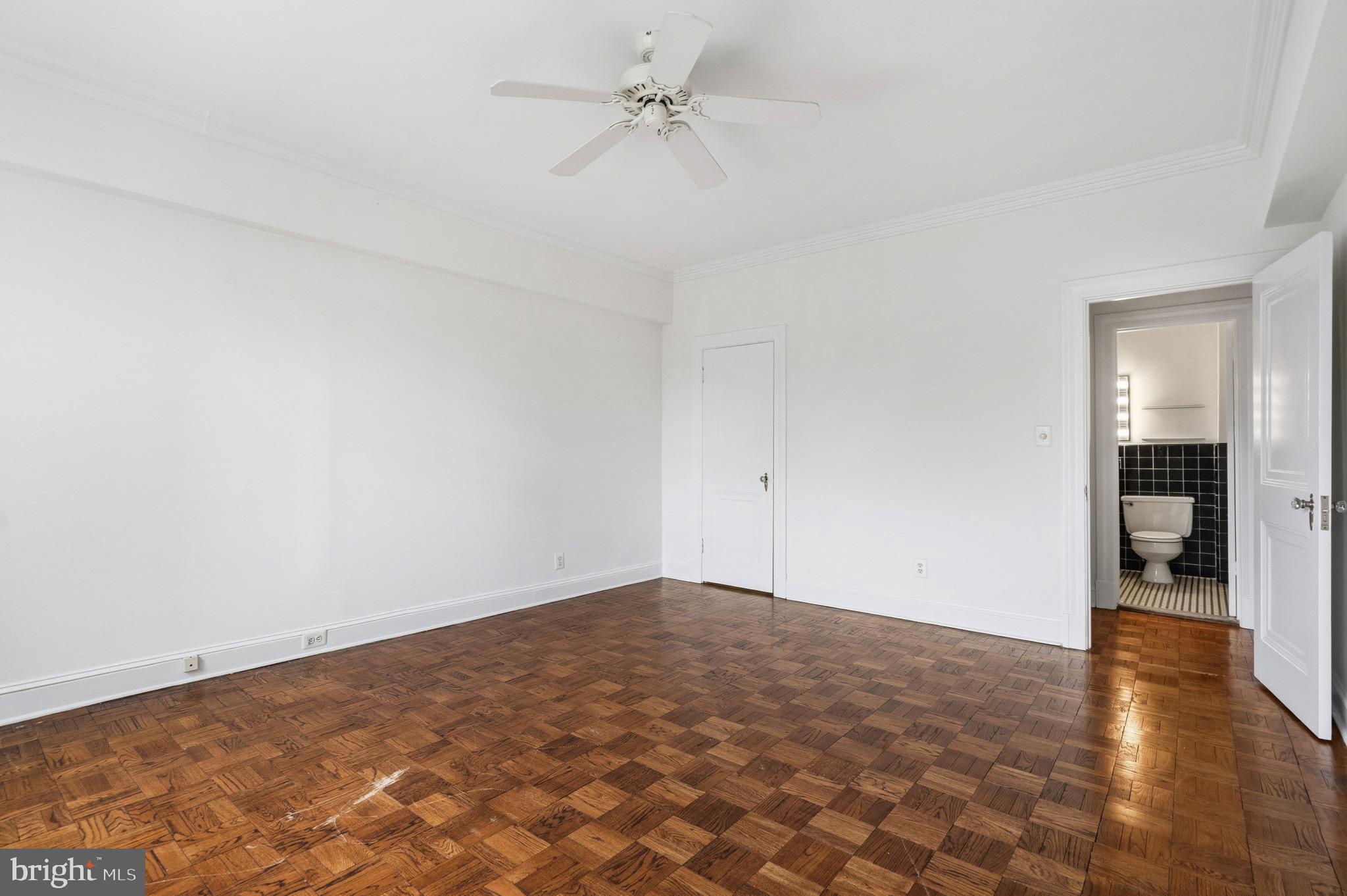 4000 Cathedral Avenue Northwest, Unit 334B/335B Washington, DC 20016 - Photo 24 of 32 an empty room with wooden floor and ceiling fan