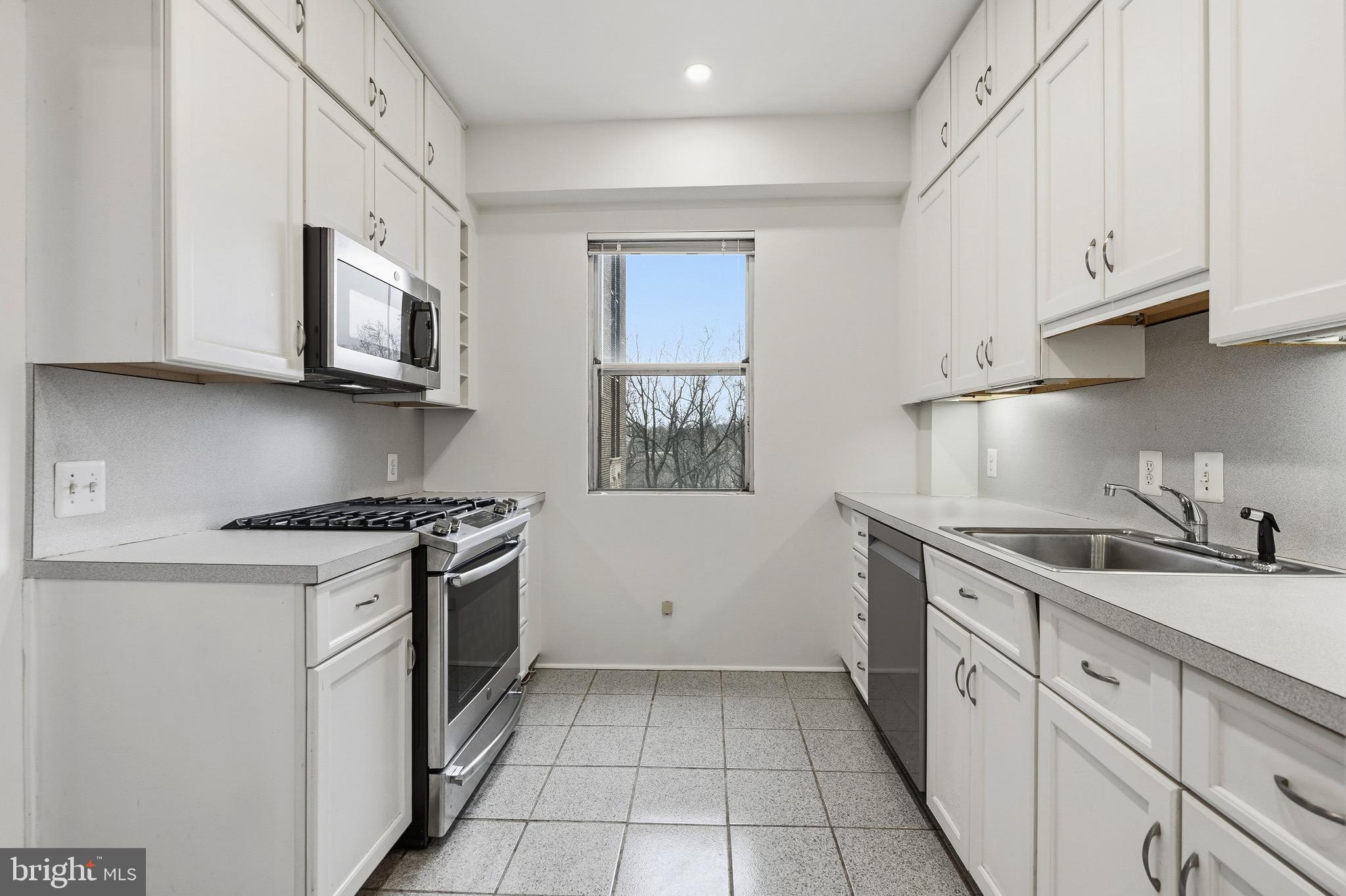 4000 Cathedral Avenue Northwest, Unit 334B/335B Washington, DC 20016 - Photo 7 of 32 a kitchen with stainless steel appliances granite countertop a stove a sink and a microwave