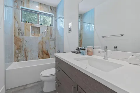 a bathroom with a double vanity sink mirror and shower