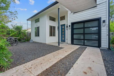 a view of a yard with plants and large trees