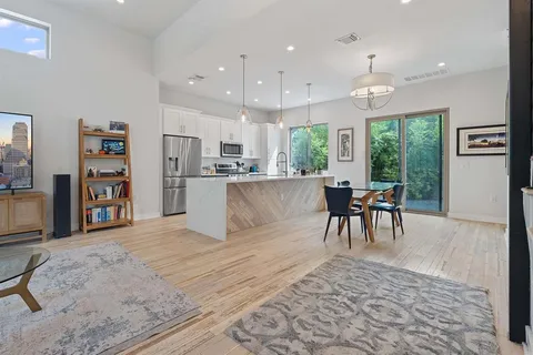 a living room with stainless steel appliances kitchen island granite countertop furniture and a table