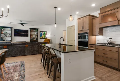 a kitchen with stainless steel appliances kitchen island granite countertop a stove a sink and a refrigerator