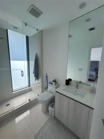 a bathroom with a double vanity sink toilet and mirror