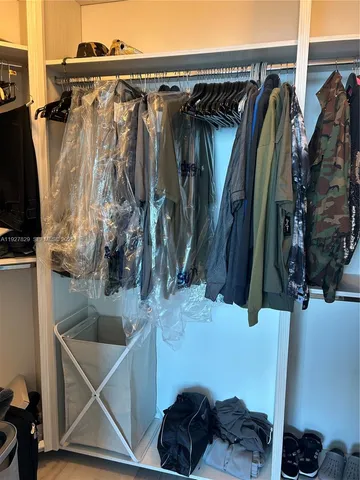 a view of walk in closet with clothes and shoes