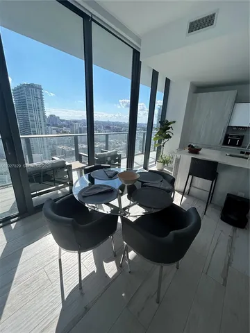 a living room with furniture and a floor to ceiling window