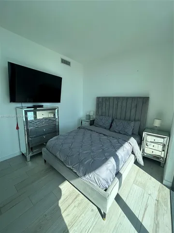 a bedroom with a bed and a television