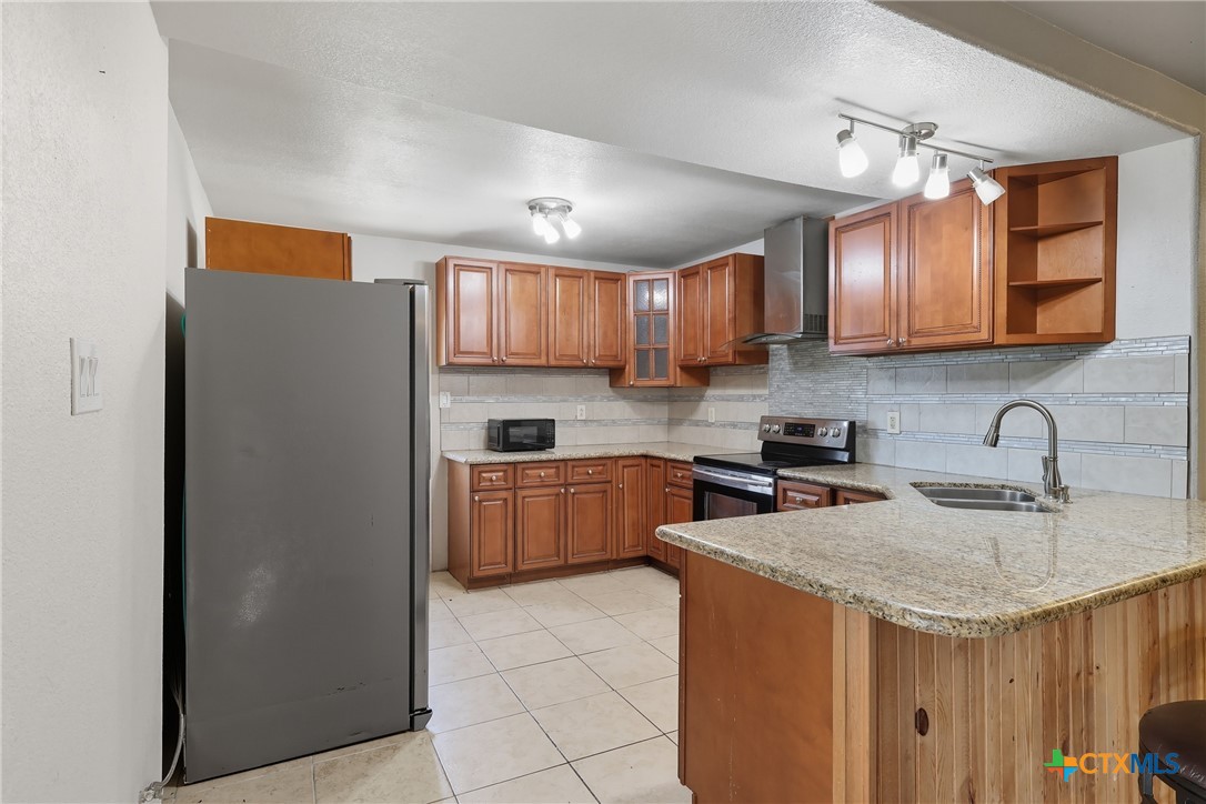 488 Alamo Beach Avenue Port Lavaca, TX 77979 - Photo 11 of 36 a kitchen with a sink a stove a refrigerator and cabinetry