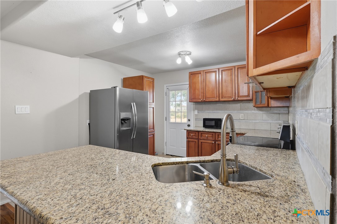 488 Alamo Beach Avenue Port Lavaca, TX 77979 - Photo 12 of 36 a kitchen with stainless steel appliances granite countertop a sink refrigerator and microwave
