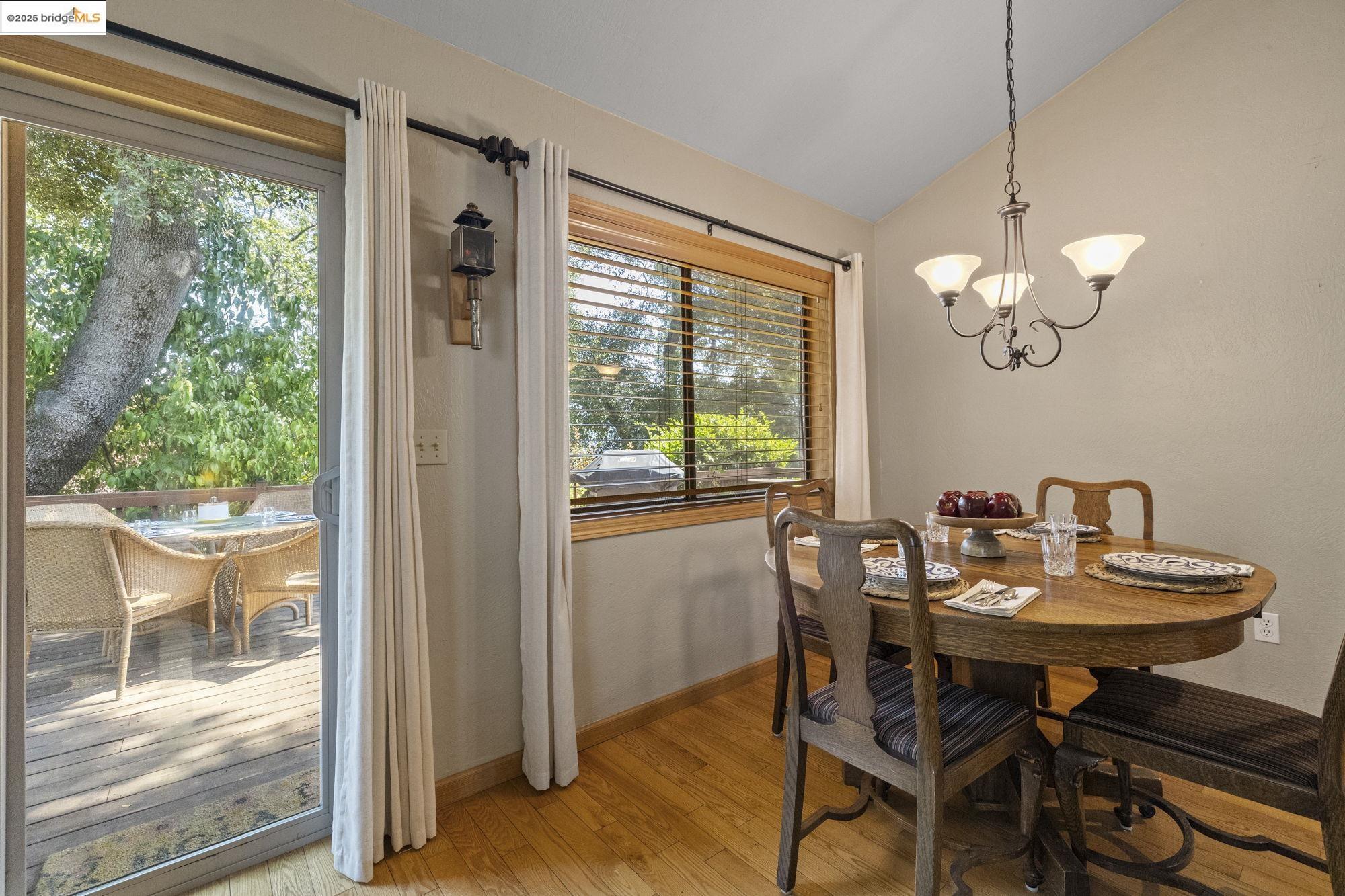 21645 La Vereda Road Sonora, CA 95370 - Photo 16 of 32 a dining room with wooden floor a chandelier a glass table and chairs